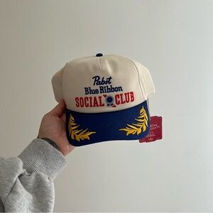 American Needle Cream and Blue Cap